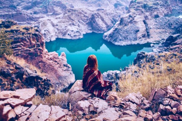 Woman sitting on mountain overlooking lake